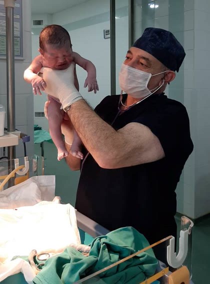 Dr. Sahib Cəfərov doğuş zalında yenidoğulmuş körpəni qiymətləndirir